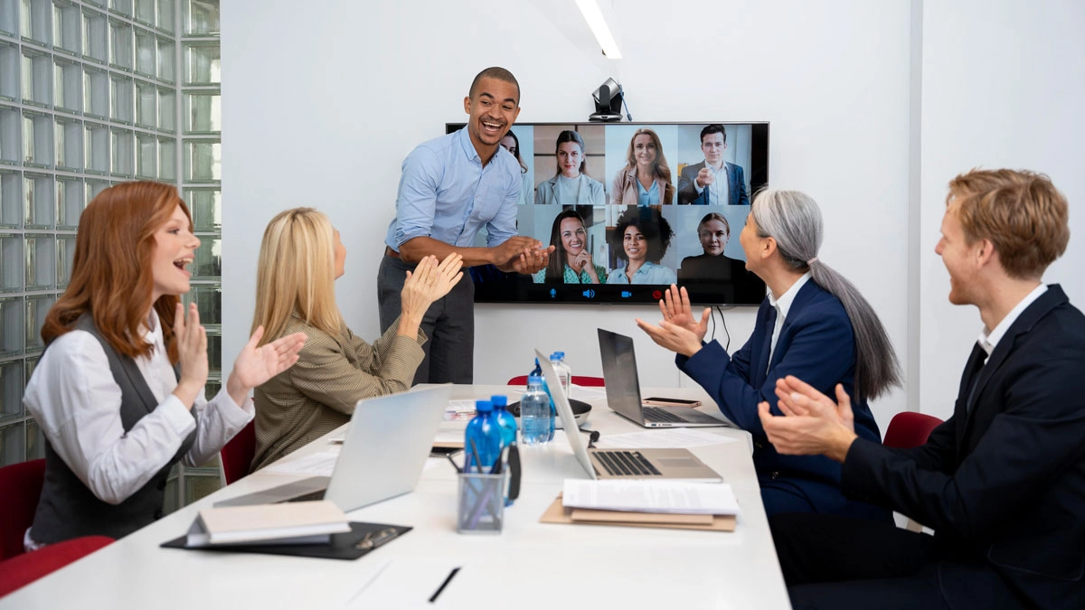 A diverse group of professionals engaged in a video conference in a modern meeting room.